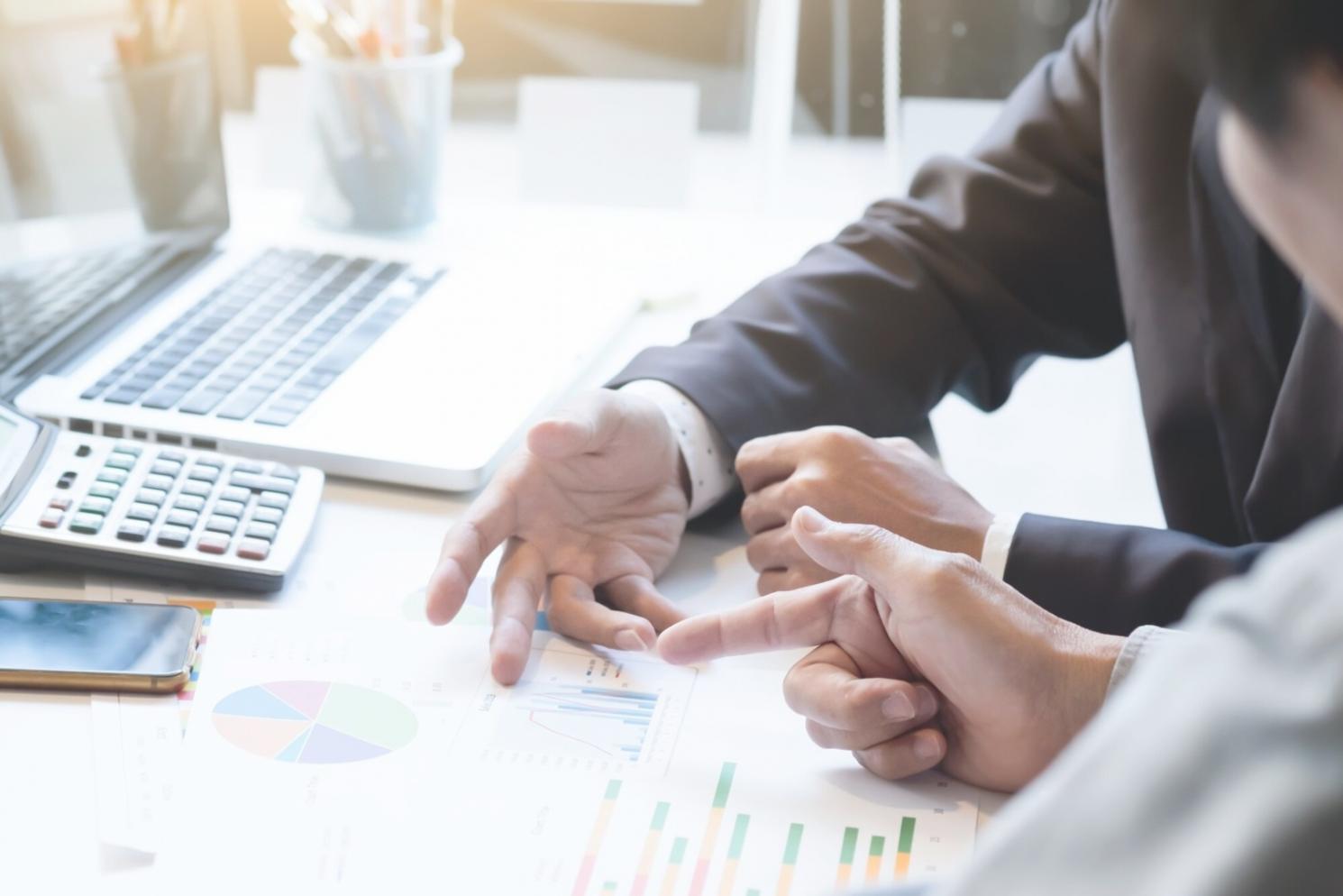 Espacio de trabajo con documentos financieros organizados y calculadora para preparar la primera sesión de planificación